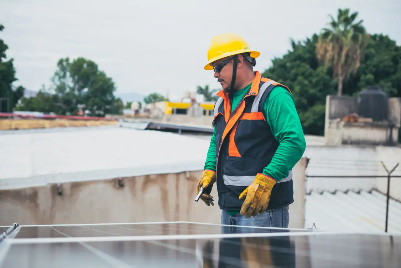 A technician in protective equipment inspecting a completed rooftop array